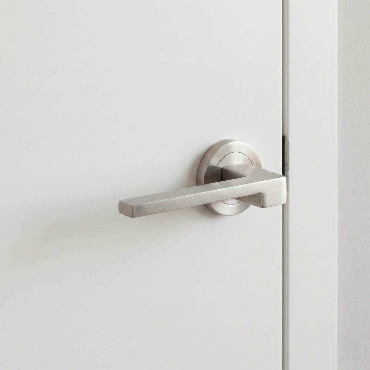 Maniglia Lugh con rosetta tonda in nichel satinato per porte