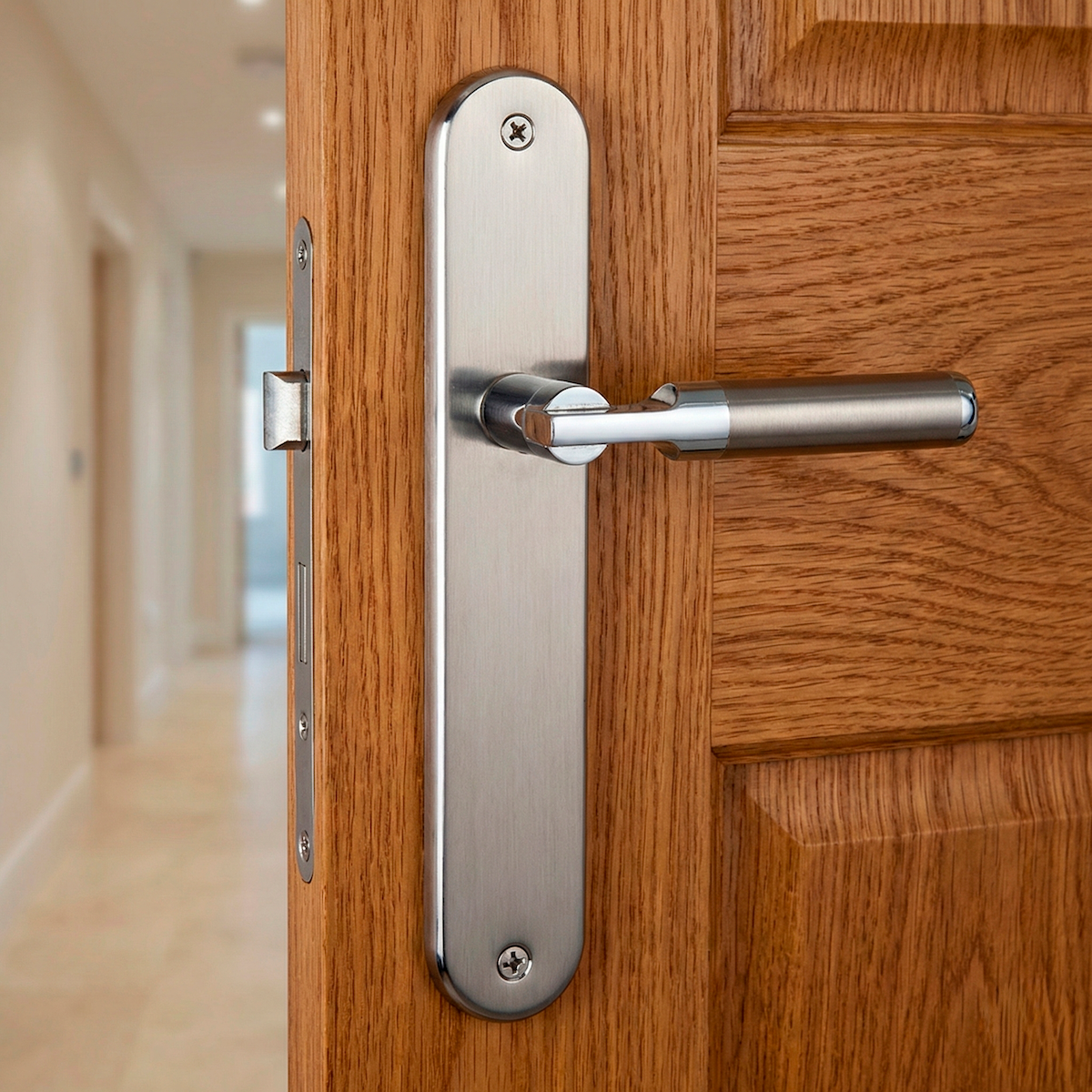 Maniglia modello '1019' d'avanguardia con placca ovale in finitura bicolore per porte